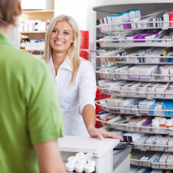 Pharmacist helping customer at counter